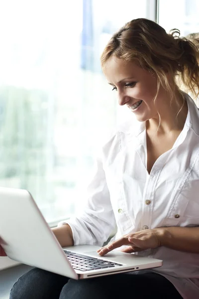Счастливая молодая красивая женщина с ноутбуком - в помещении — стоковое фото
