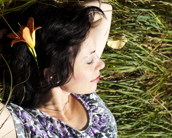 Adult woman resting on a green field — Stock Photo, Image