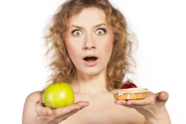 Beautiful blonde choosing, between an apple and a cake — Stock Photo, Image