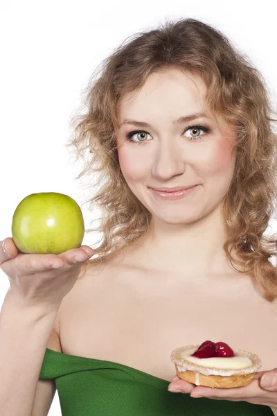 Όμορφη ξανθιά επιλογή, μεταξύ ένα μήλο και ένα κέικ — Φωτογραφία Αρχείου