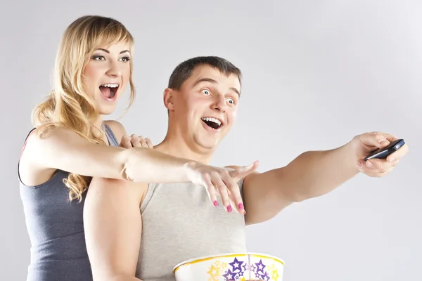 Young couple eating popcorn, watching TV — Stock Photo, Image