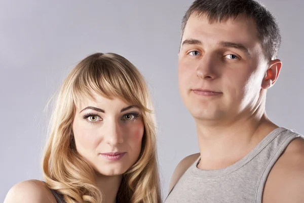 年轻夫妇一起在灰色的背景上 — 图库照片