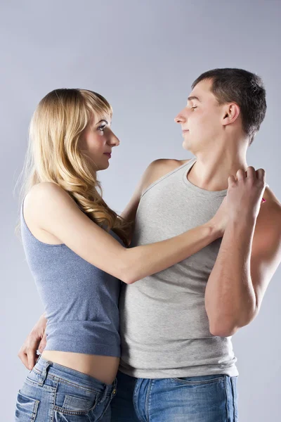 Young couple together on grey background — Stock Photo, Image