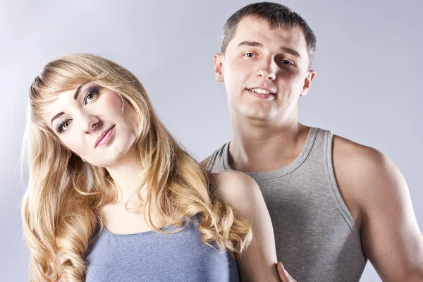 Young couple together on grey background — Stock Photo, Image