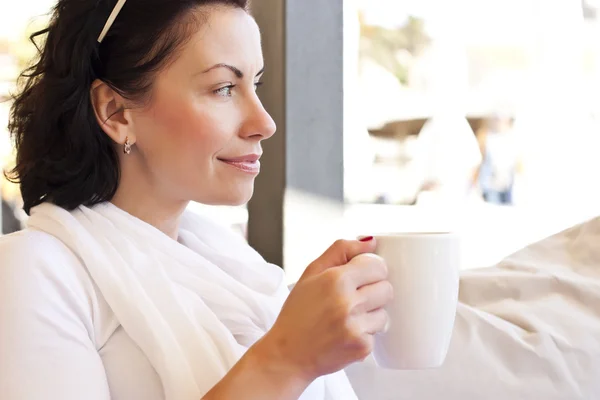 Молодая привлекательная женщина, сидящая в кафе с кофе — стоковое фото