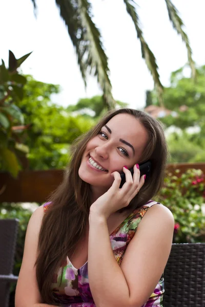 Mooie lachende meisje gesprekken op mobiele telefoon buitenshuis — Stockfoto
