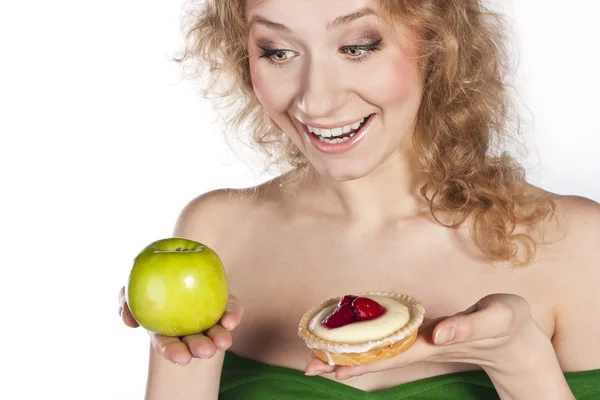 性格开朗的年轻女子，苹果和蛋糕之间选择 — 图库照片