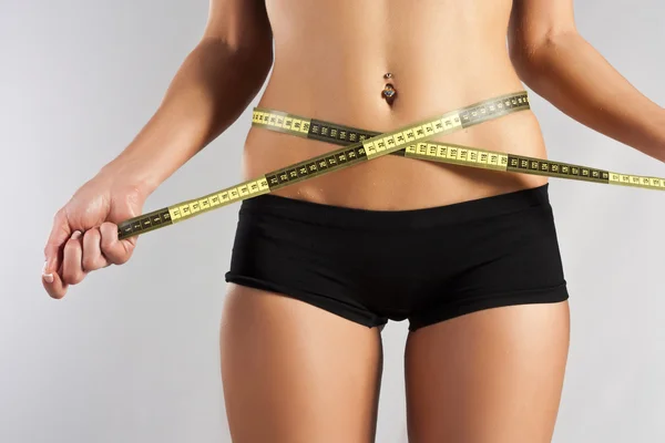 Mujer joven delgada mide la cintura — Foto de Stock