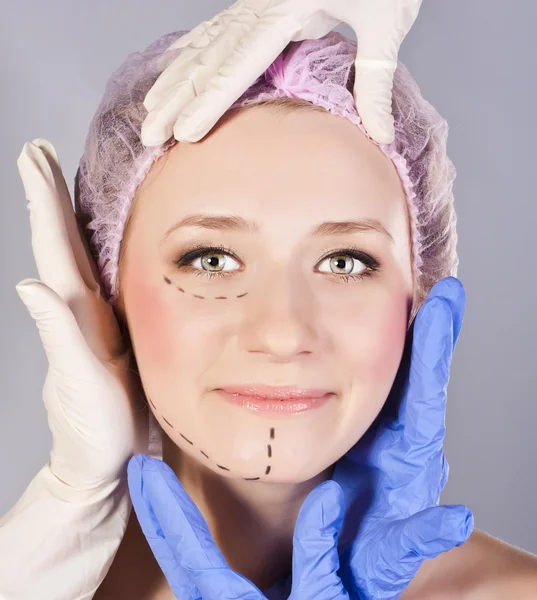 Cirurgia plástica tocando a cabeça de um belo rosto feminino — Fotografia de Stock