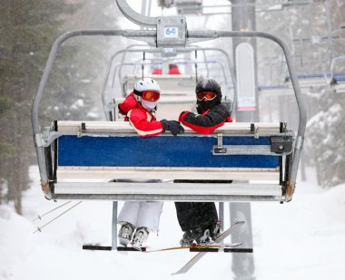 Skiers on a ski-lift clipart