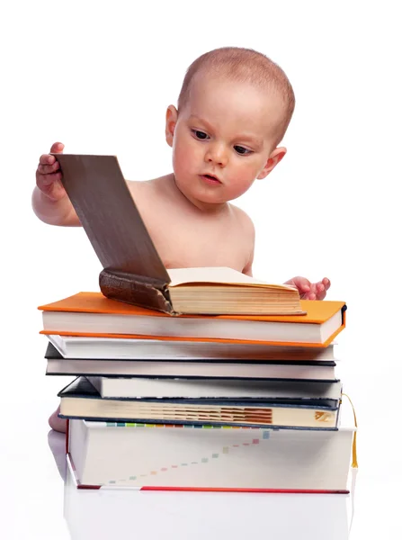Little boy sitting behind a stack of books — Stock Photo, Image