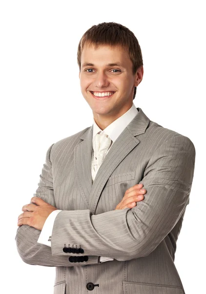 Молодой улыбающийся мужчина, стоящий со скрещенными руками — стоковое фото