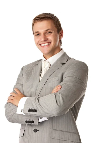 Молодой улыбающийся мужчина, стоящий со скрещенными руками — стоковое фото