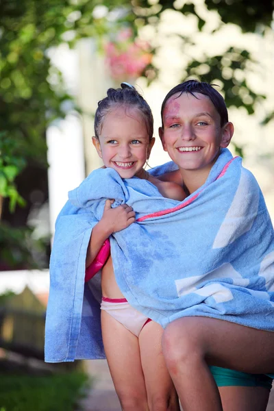 Fröhliche Geschwister nach dem Schwimmen im Freien in ein Handtuch gewickelt — Stockfoto