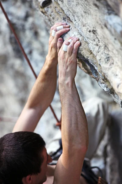 Vista de perto das mãos de um alpinista em um penhasco — Fotografia de Stock