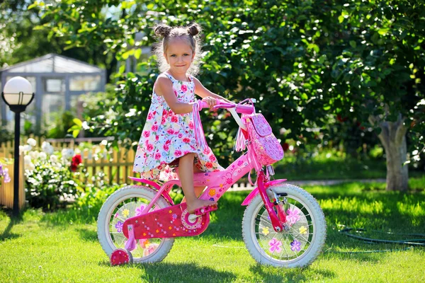 Portrait of a cute four-year old girl riding her bicycle — Stock Photo, Image