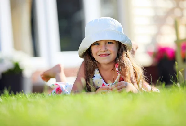 外の芝生の上に横たわってかわいい 4 年間女の子 — ストック写真