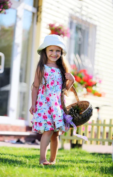 Cute four-year girl carrying a basket outdoors — Stock Photo, Image