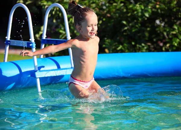 Linda niña de cuatro años saltando en una caca de natación — Foto de Stock
