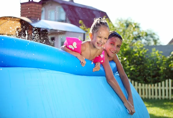 Barnen simmar i en uppblåsbar pool — Stockfoto