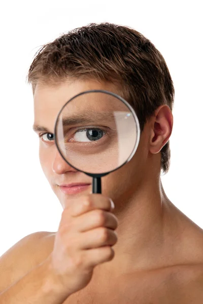 stock image Cute young man looking through a magnifying glass