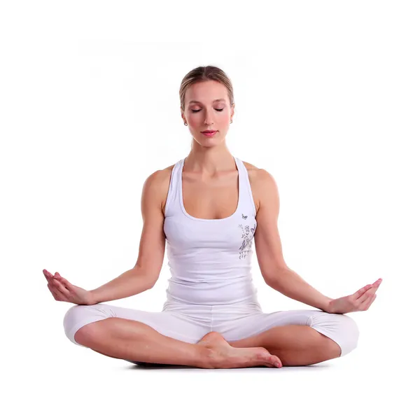 Junge Frau praktiziert Yoga, sitzt in einer Lotusposition — Stockfoto