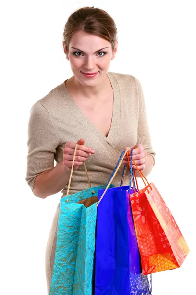 Mujer joven con bolsas de compras mirando a la cámara y sonriendo —  Fotos de Stock