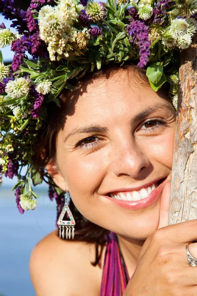 Πανέμορφη νεαρή γυναίκα που φοράει ένα floral στεφάνι — Φωτογραφία Αρχείου