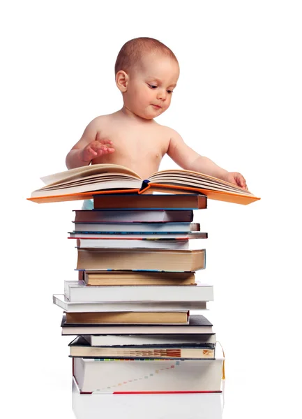 Portrait of a little boy standing behind a stack of books — Stock Photo, Image
