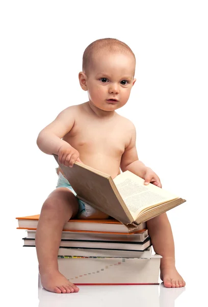 書籍のスタック上に座っている小さな男の子の肖像画 — 图库照片