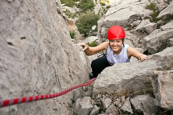 Ritratto di allegra arrampicatrice che sale su una roccia — Foto Stock