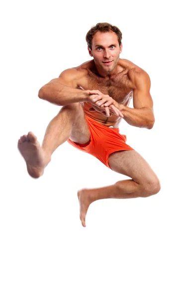 Молодой мускулистый мужчина прыгает на белом — стоковое фото