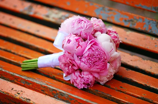 Closeup véve egy menyasszony kezében pünkösdi rózsa csokor — Stock Fotó