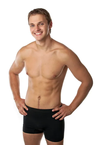 Fröhlicher junger Mann in Badehose vor weißem Hintergrund — Stockfoto