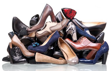 Pile of various female shoes isolated over white