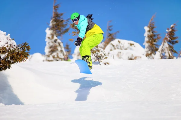 Сноубордист прыгает по горному склону — стоковое фото