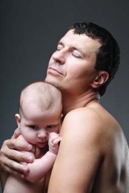 Father holding softly his baby son. clipart
