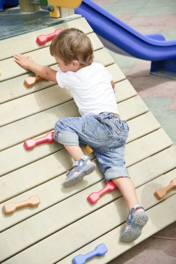 Little boy climb in playground.