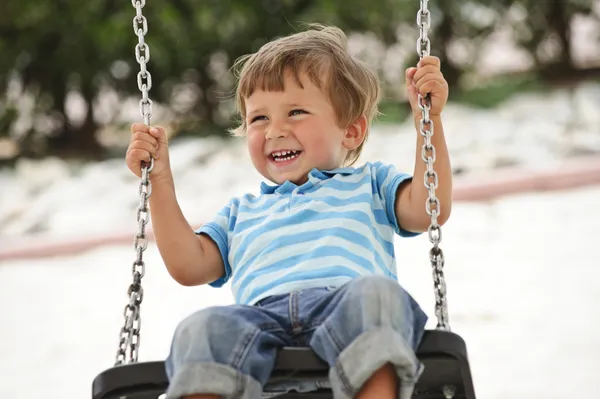 Little boy having fun on chain swing — Stock Photo, Image
