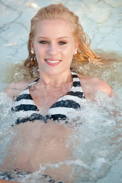 Attraktiv blond tjej i bikini badkläder i poolen på sen sommareftermiddag — 图库照片