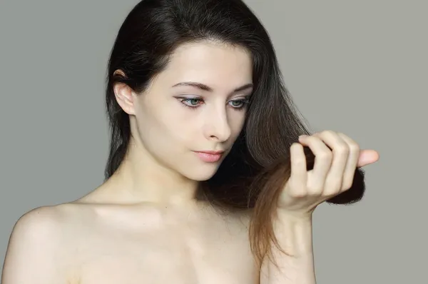 Mulher segurando o cabelo danificado e olhar infeliz — Fotografia de Stock