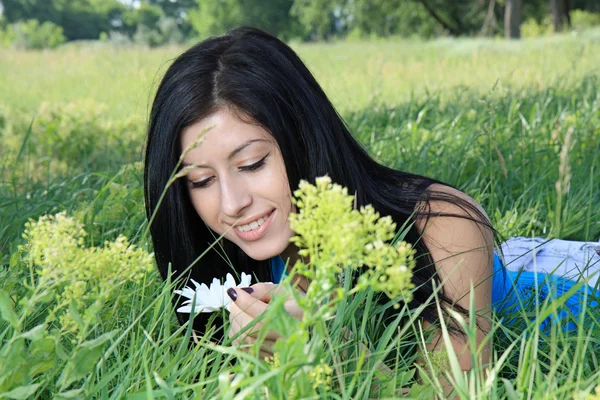 Bela jovem mulher deitada na grama — Fotografia de Stock