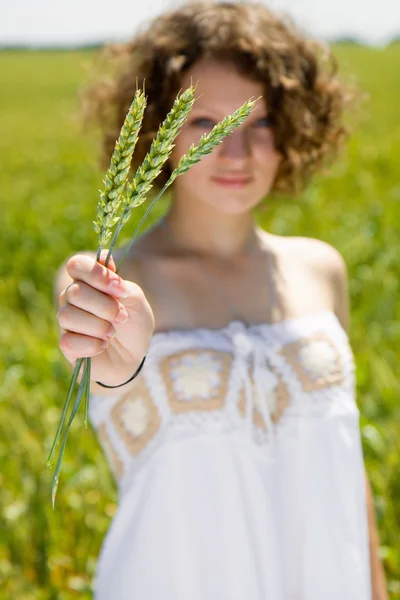 Young girl holding a ear of wheat — Stock Photo, Image