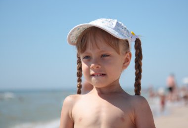 Portrait of a little girl playing on the beach. clipart