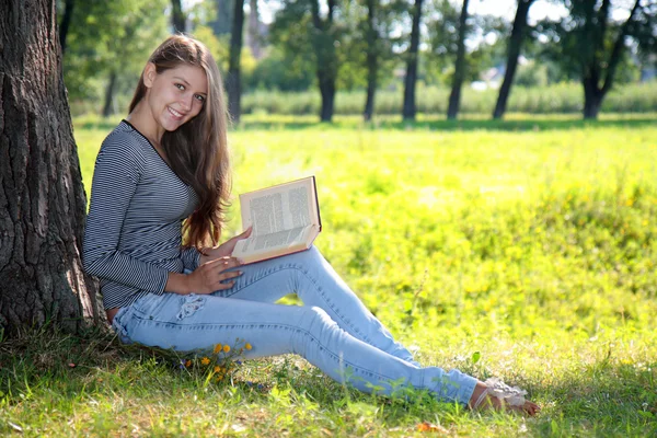 在公园里拿着一本书的女孩 — 图库照片