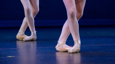 Duo balerinler ayakları koyu mavi zemin üzerinde çarpı işareti.