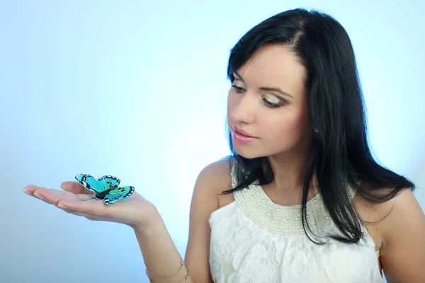 stock image Attractive woman with butterfly over blue background