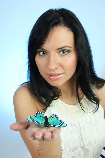 Jolie femme avec papillon sur fond bleu — Photo