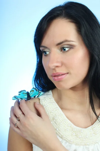 Donna attraente con farfalla su sfondo blu — Foto Stock