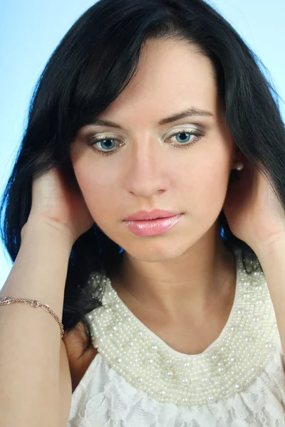 Çekici bir kadın saçı mavi arka plan üzerinde düzeltme — Stok fotoğraf